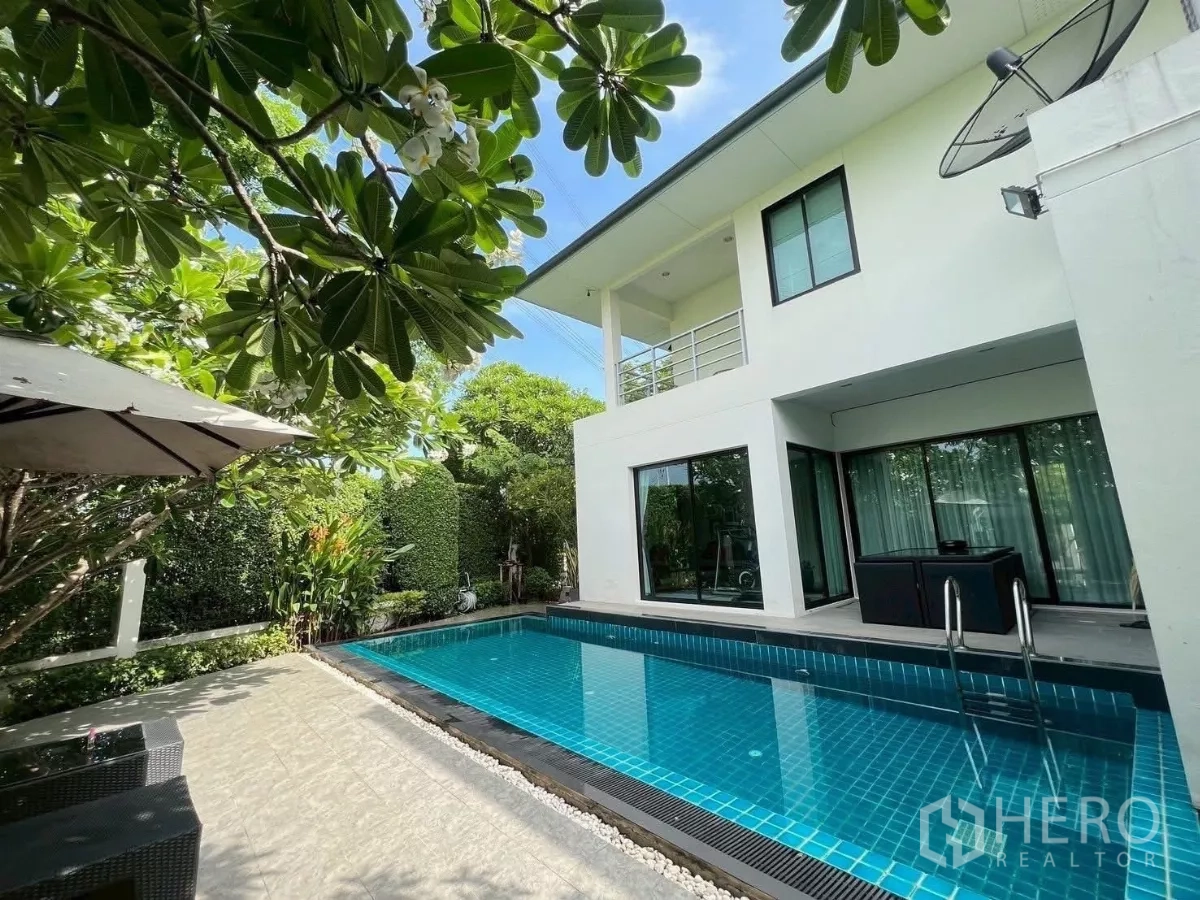 Detached House for rent or sale in Prawet, Bangkok - Rear exterior showing pool beside the two-storey home and covered terrace.