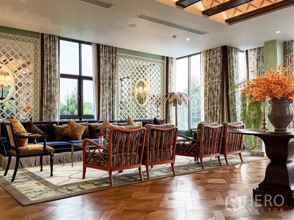 Detached House for rent in Bang Khen, Bangkok - Refined clubhouse lounge with patterned rugs, wood chairs and tall windows.