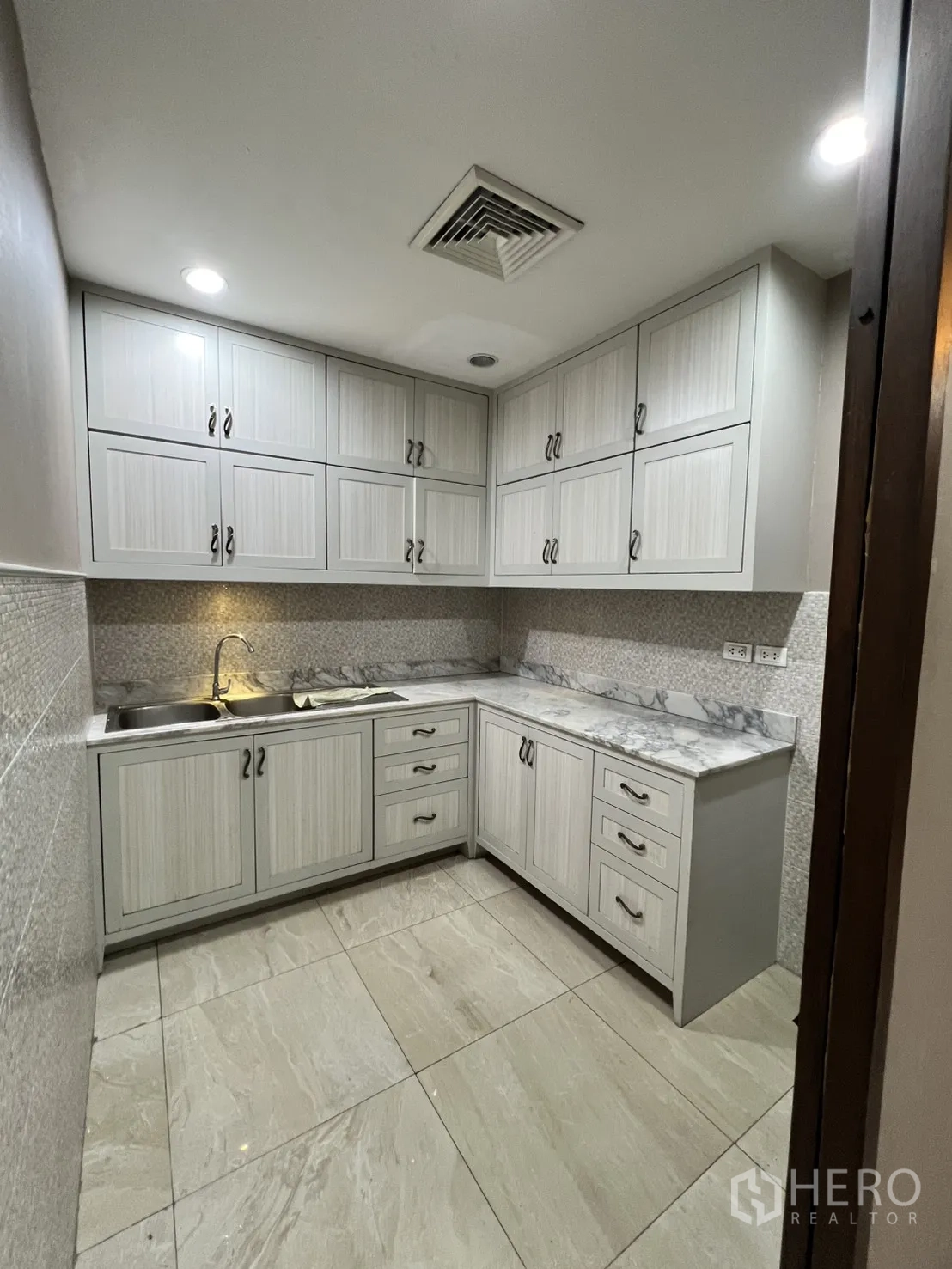 Office Space for rent in Watthana, Bangkok - Pantry with upper and lower cabinets, marble-look countertop, and sink.