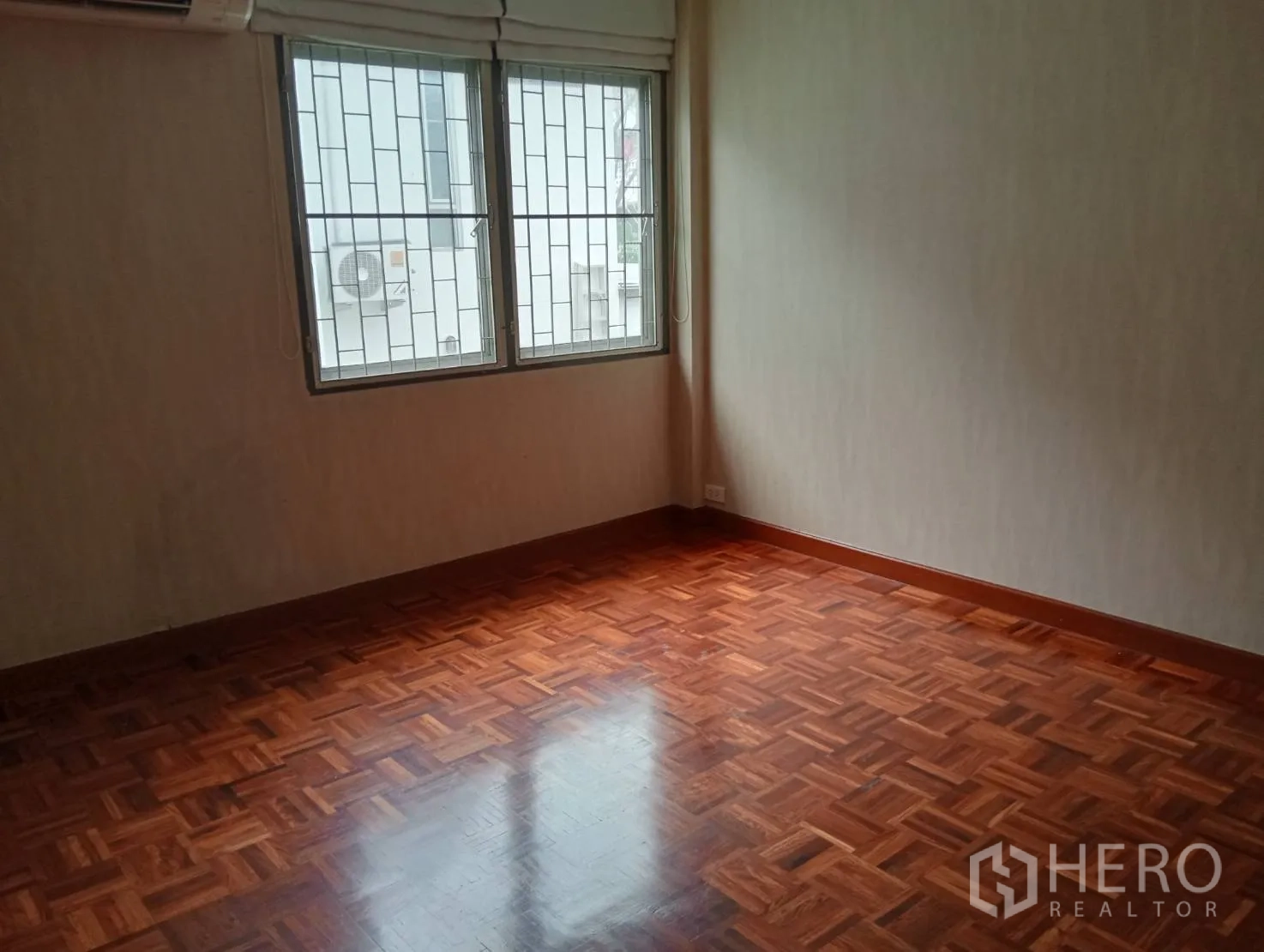 Home Office for rent in Khlong Toei, Bangkok - Second bedroom with large windows and parquet flooring.