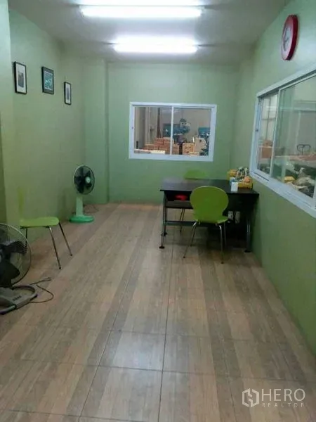Warehouse for rent in Samut Prakan - Air-conditioned office room inside the warehouse with green walls and tile flooring.