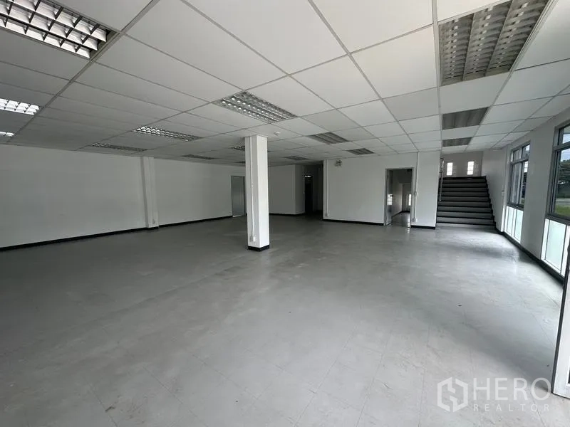 Factory for rent in Pathum Thani - Ground-floor office lobby with staircase and glass windows.