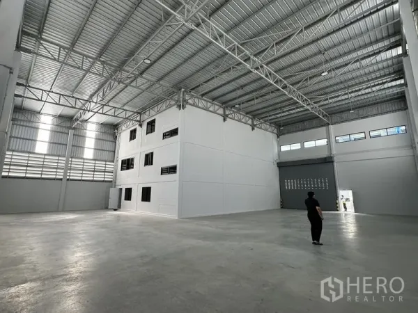 Warehouse for rent in Bang Phli, Samut Prakan - Spacious high-clearance warehouse interior with steel trusses and polished concrete floor.
