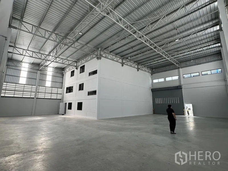 Warehouse for rent in Bang Phli, Samut Prakan - Spacious high-clearance warehouse interior with steel trusses and polished concrete floor.