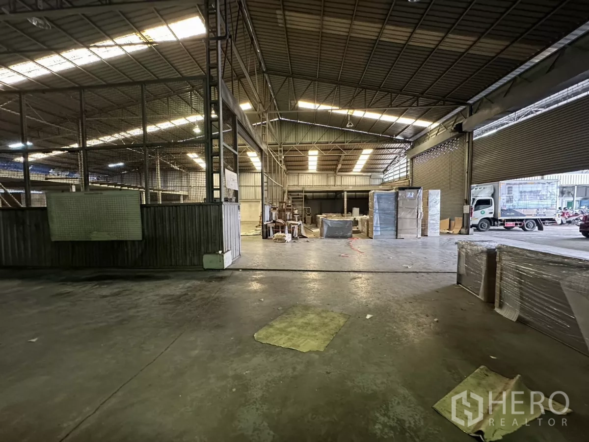 Warehouse for rent in Yan Nawa, Bangkok - View toward the wide loading zone with roller shutters and a delivery truck parked outside.