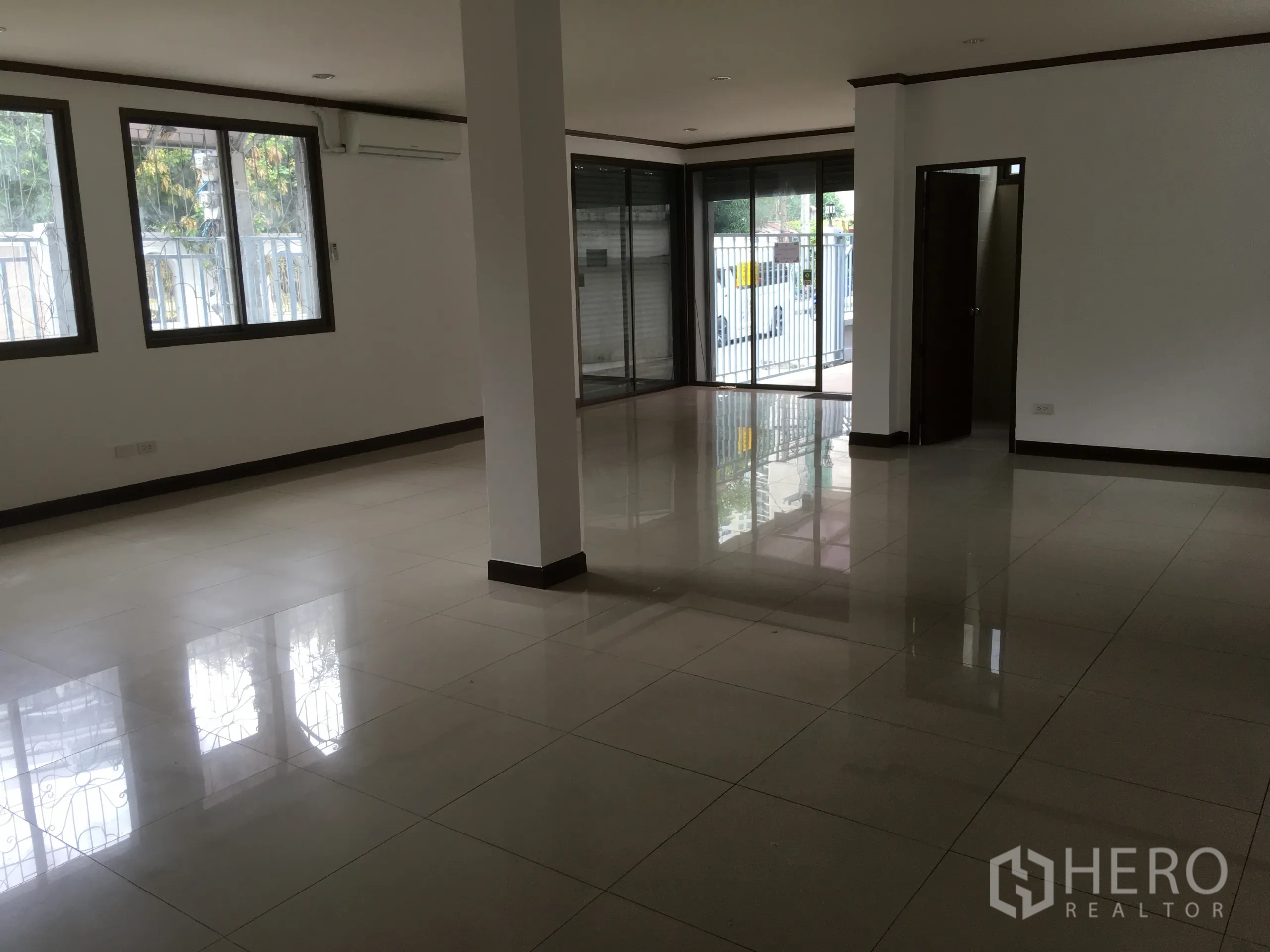 联排别墅 出租在Khlong Toei, Bangkok - 一层空间，落地窗与推拉玻璃门，临街安全栅栏