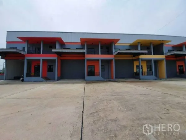Factory for rent in Mueang Samut Sakhon, Samut Sakhon - Modern row of factory units with colorful facades, covered loading bays, and roller shutter doors.