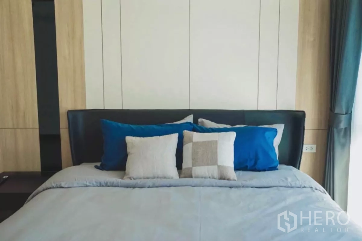Detached House for rent in Bang Phli, Samut Prakan - Close-up of upholstered bed with blue and neutral throw pillows.