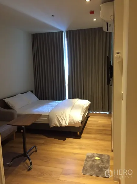Condominium for rent or sale in Khlong Toei, Bangkok - Entry view to bedroom with floor-to-ceiling curtains and wood flooring near BTS Phrom Phong.