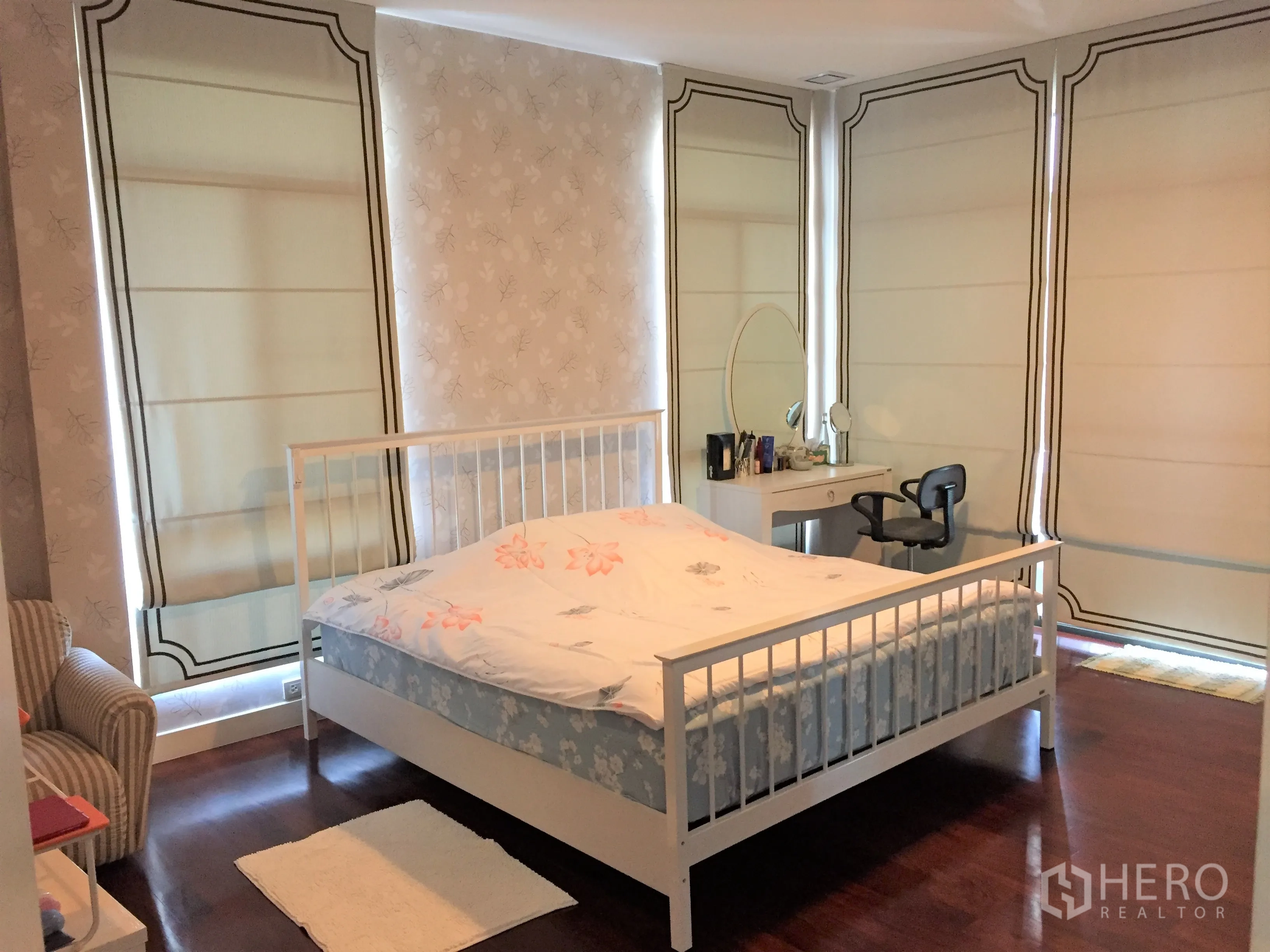 Detached House for rent or sale in Prawet, Bangkok - Master bedroom with wood floors, white bed frame, dressing table and Roman blinds.