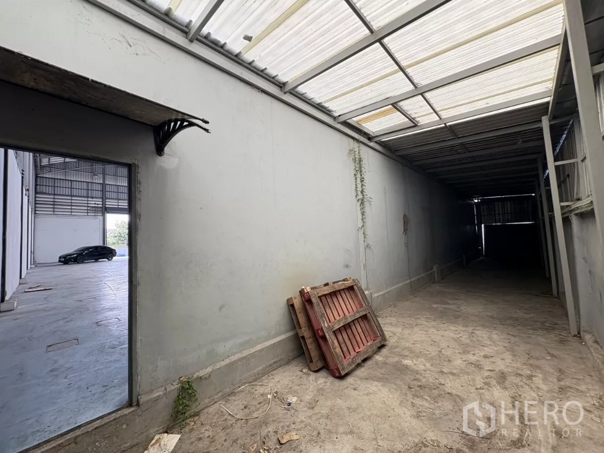Warehouse for rent in Bang Phli, Samut Prakan - Side access passage connecting to the warehouse under translucent roofing.