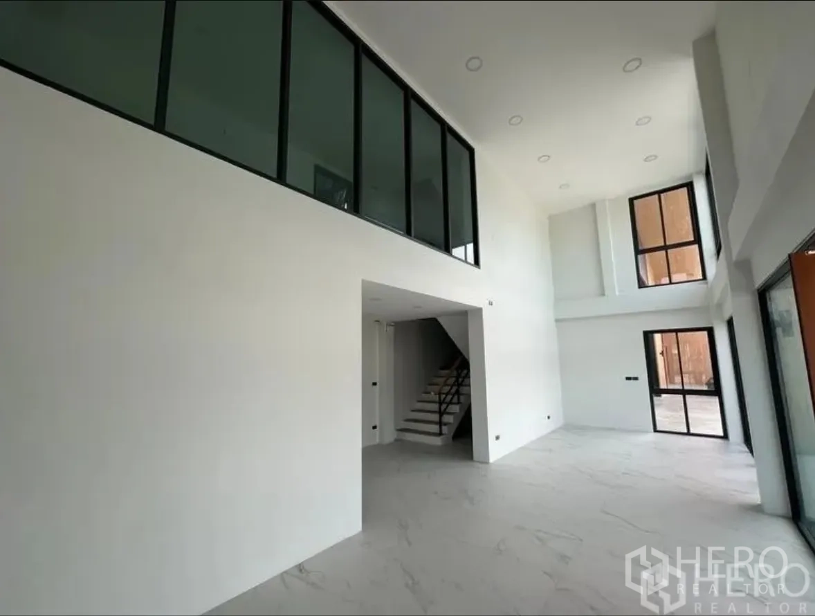 Warehouse for sale in Lam Luk Ka, Pathum Thani - Bright double-height office area with staircase and expansive glazing to the front.