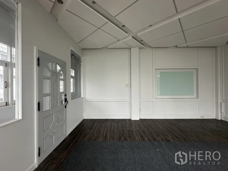Retail Space for rent in Bang Rak, Bangkok - Bright interior with paneled walls, acoustic ceiling, and a windowed door.