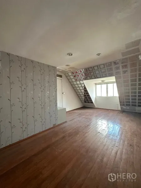 Retail Space for rent in Watthana, Bangkok - Spacious room with wood flooring, patterned wallpaper and sloped ceiling