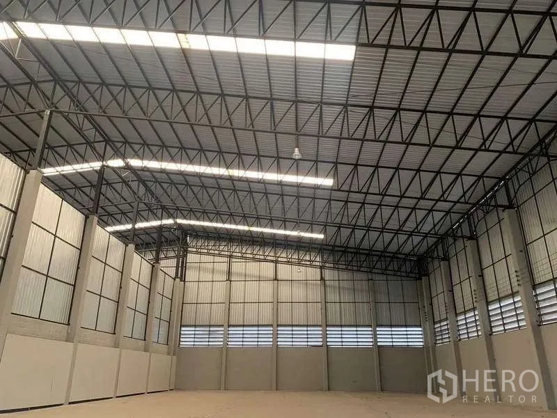 Warehouse for rent in Bang Pa-in, Phra Nakhon Si Ayutthaya - Spacious warehouse interior featuring a high clear-height steel truss roof and natural light panels.