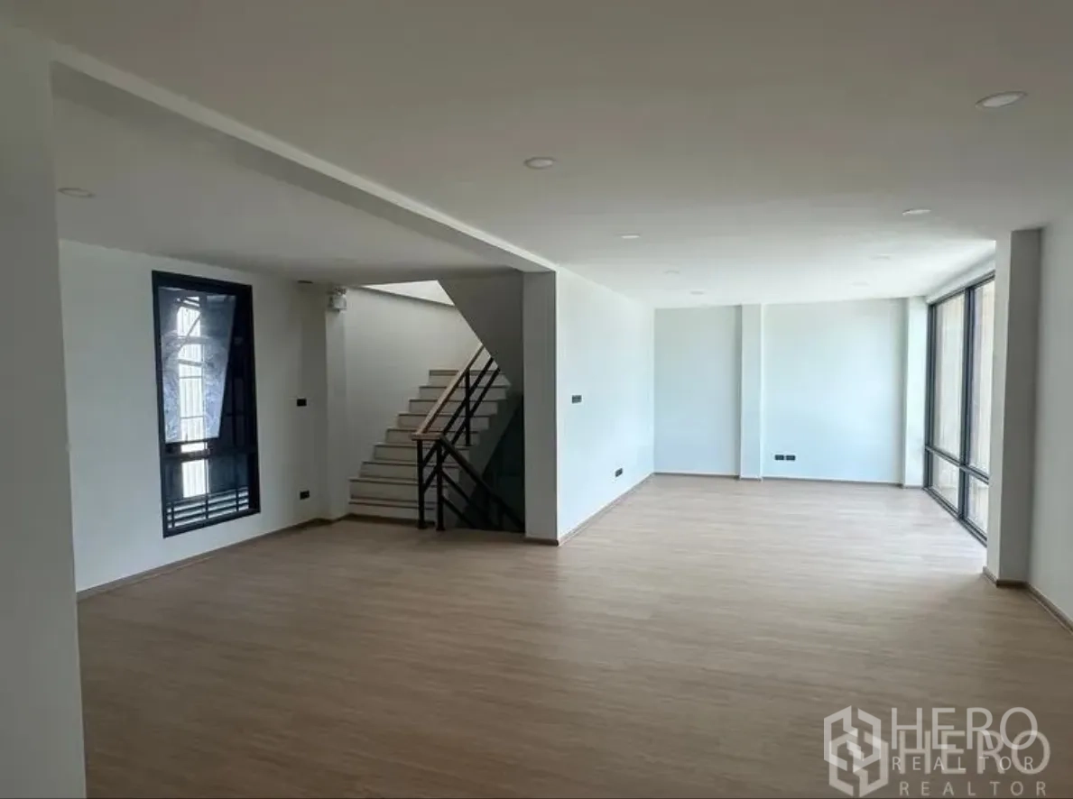 Warehouse for sale in Lam Luk Ka, Pathum Thani - Open-plan office level with staircase, downlights and floor-to-ceiling windows.