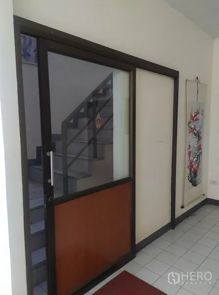 Home Office for rent in Yan Nawa, Bangkok - Entrance corridor with dark-framed glass door beside an internal staircase.
