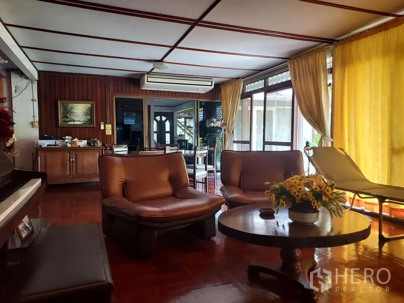 Detached House for rent in Mueang Samut Prakan, Samut Prakan - Cozy lounge with leather chairs, a piano and floor‑to‑ceiling curtains.