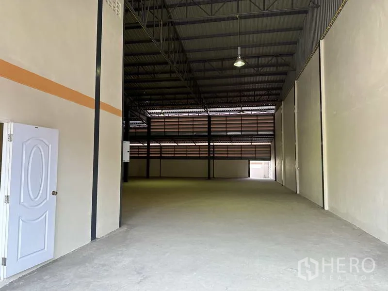 Factory for sale in Mueang Samut Prakan, Samut Prakan - Spacious warehouse interior with high steel truss roof and smooth concrete floor.