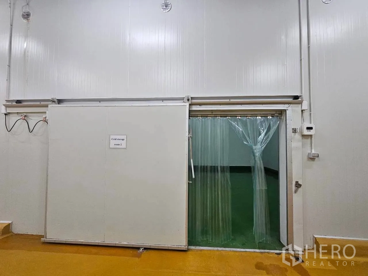 Factory for rent in Mueang Samut Sakhon, Samut Sakhon - Sliding cold-room door with clear strip curtains at entry.
