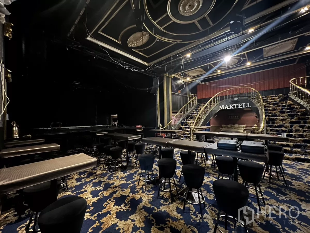 Retail Space for rent in Watthana, Bangkok - Event hall view with tables, bar stools and ornate carpet.