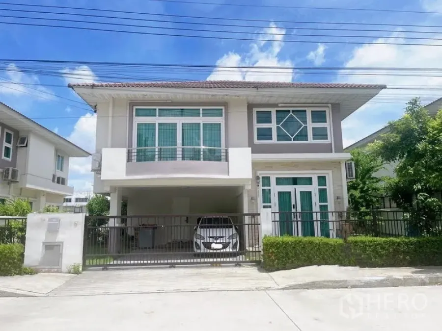 Detached House for sale in Bang Phli, Samut Prakan - Modern two-storey detached house exterior with balcony, gated driveway and covered carport on a sunny day.