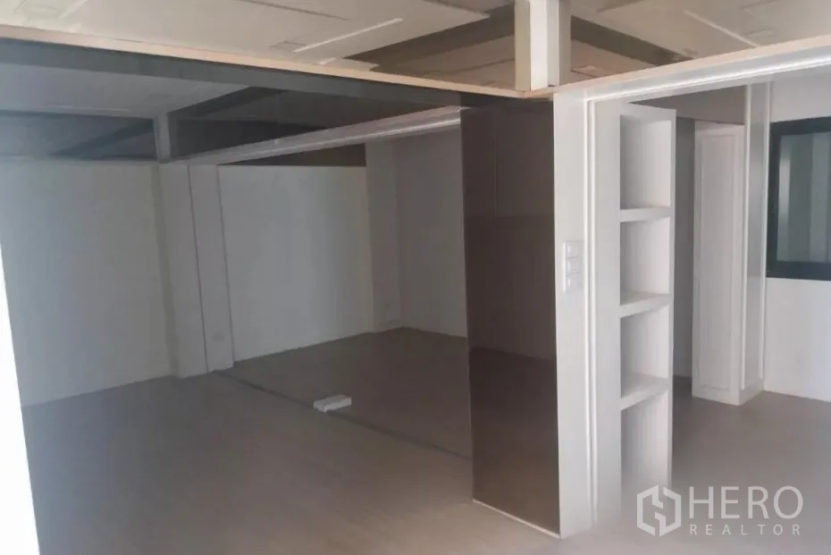 Retail Space for rent - Partitioned area featuring display shelving and a mirrored wall for product showcasing.