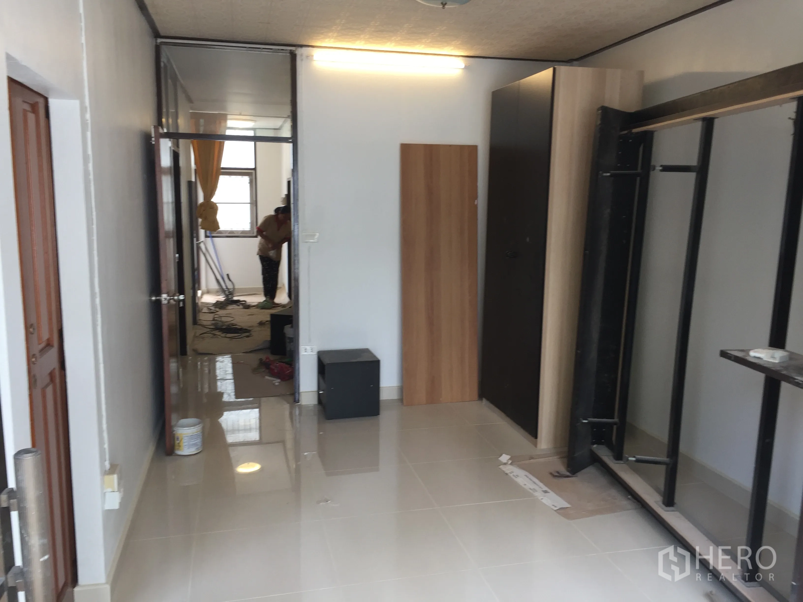 联排别墅 出租在Khlong Toei, Bangkok - 楼上房间施工中，亮面地砖与衣柜板材，通向另一间明亮房间。