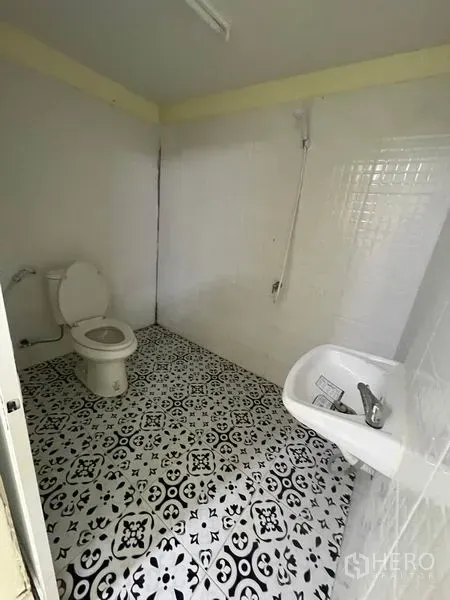 Warehouse for rent in Khlong Luang, Pathum Thani - Clean tiled bathroom with toilet, sink and shower inside the facility.