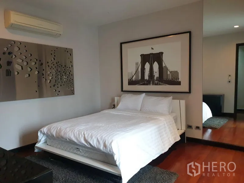 Detached House for sale in Watthana, Bangkok - Bedroom with white bedding, wood floor and large framed bridge artwork.