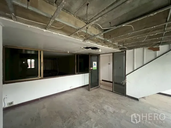 Shophouse for rent in Phra Khanong, Bangkok - Open workspace featuring sliding glass panels and unfinished ceiling.