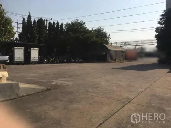 Warehouse for rent in Bang Phli, Samut Prakan - Expansive concrete yard providing generous parking and maneuvering space for trucks.
