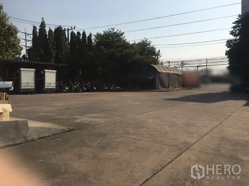 Warehouse for rent in Bang Phli, Samut Prakan - Expansive concrete yard providing generous parking and maneuvering space for trucks.