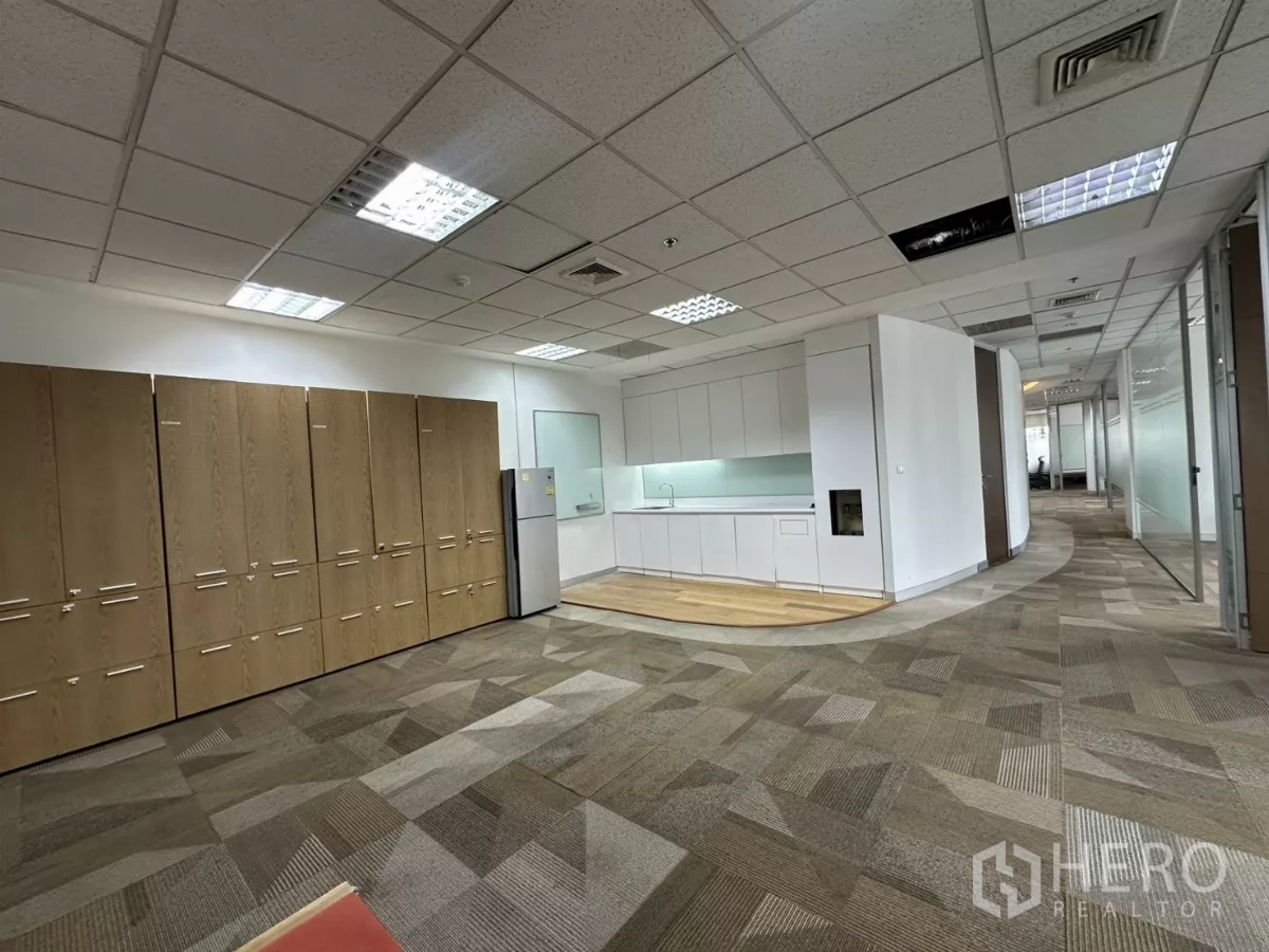 Office Space for rent in Watthana, Bangkok - Pantry and break area with tall cabinets, refrigerator and a curved hallway.