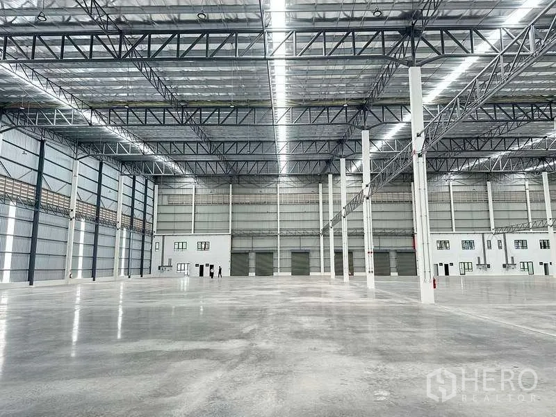 Factory for rent in Bang Phli, Samut Prakan - High-bay factory space with loading bays and integrated office rooms along the wall.