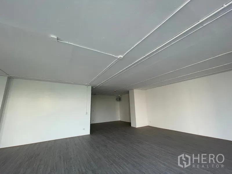 Office Space for rent in Bang Rak, Bangkok - Ceiling detail showing exposed electrical conduits in a clean white office.