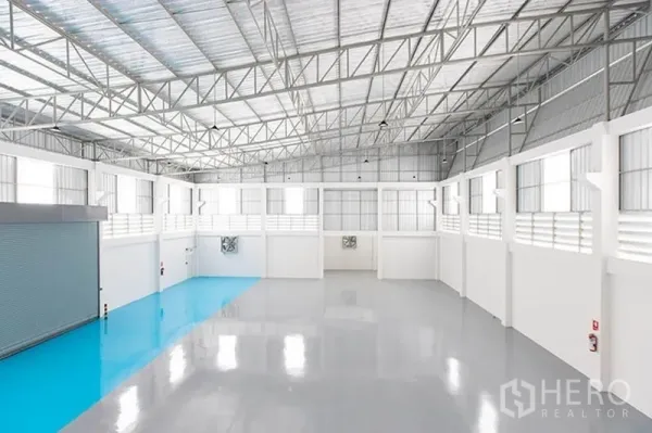 Factory for rent in Bang Phli, Samut Prakan - High-bay warehouse interior showing skylights, ventilation fans, and open column-free space.