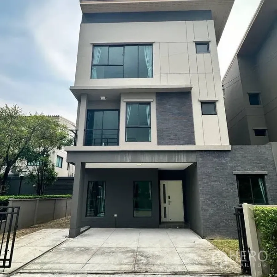 Detached House for rent in Khan Na Yao, Bangkok - Front exterior of modern three‑storey detached house with covered parking.