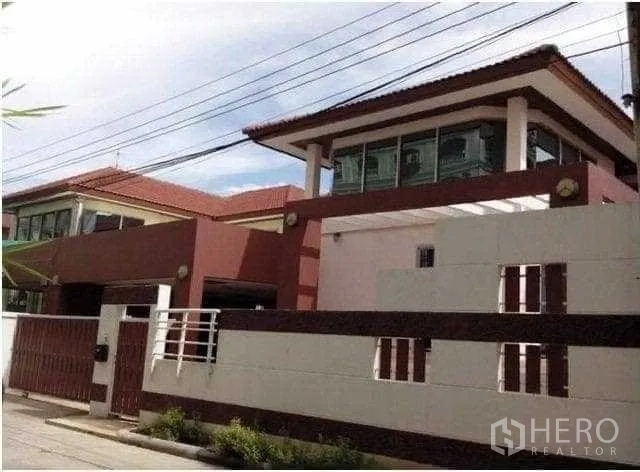 Home Office for rent in Khlong Toei, Bangkok - Modern two-storey home with high perimeter wall and red-brown facade.