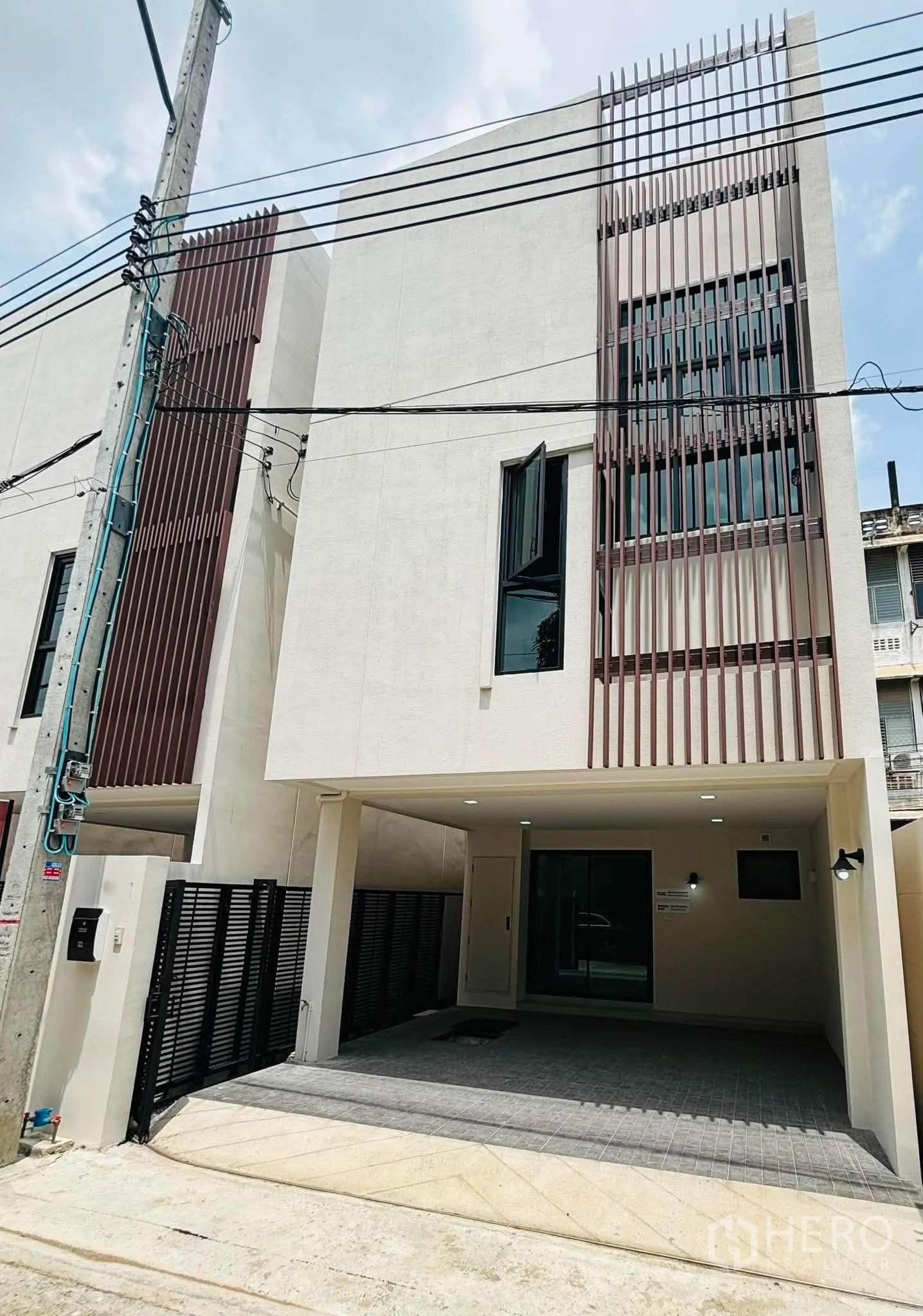 家庭办公室 for rent in Phra Khanong, Bangkok - 现代多层外观的家用办公楼，设有有顶车位与竖向格栅。