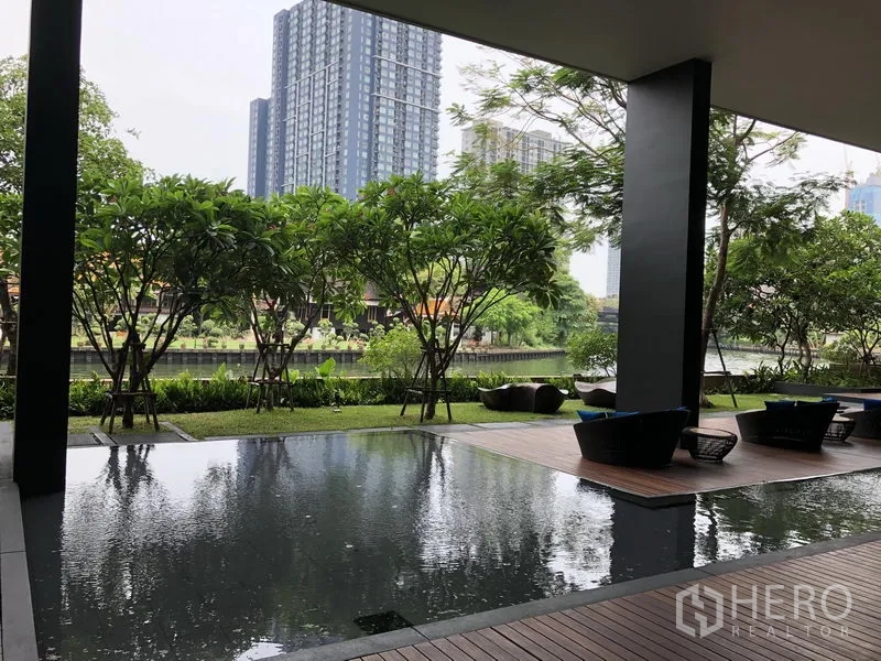 Condominium for rent in Watthana, Bangkok - Covered outdoor lounge with reflecting pool and canal view amid landscaped gardens.