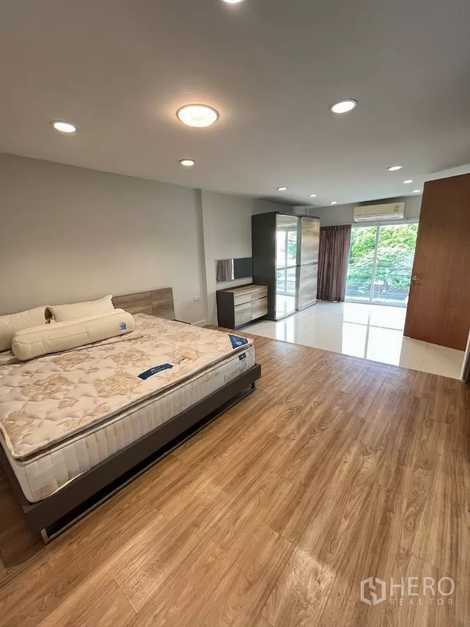Home Office for rent in Khlong Toei, Bangkok - Large bedroom with wood flooring, wardrobe and sliding doors to balcony.
