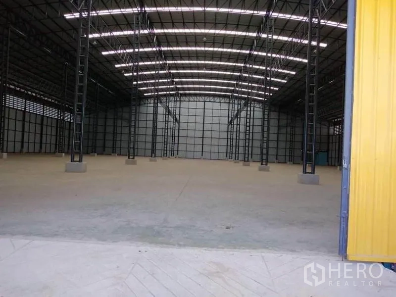 โรงงาน ให้เช่าในMueang Samut Prakan, Samut Prakan - มองจากทางเข้าเห็นประตูบานเลื่อนสีเหลือง และโครงหลังคาสูงสว่าง