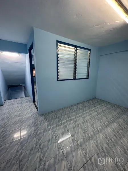 Shophouse for rent in Bang Na, Bangkok - Compact room with louvered window, doorway and staircase, finished with tile flooring.