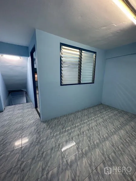 Shophouse for rent in Bang Na, Bangkok - Compact room with louvered window, doorway and staircase, finished with tile flooring.