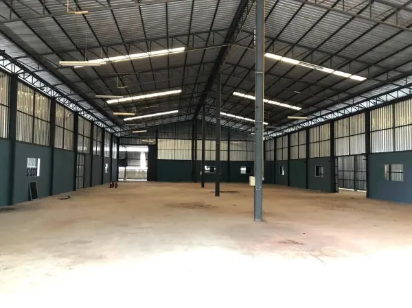 Factory for rent in Plaeng Yao, Chachoengsao - Open warehouse hall with metal cladding, suspended lights, and a concrete floor.