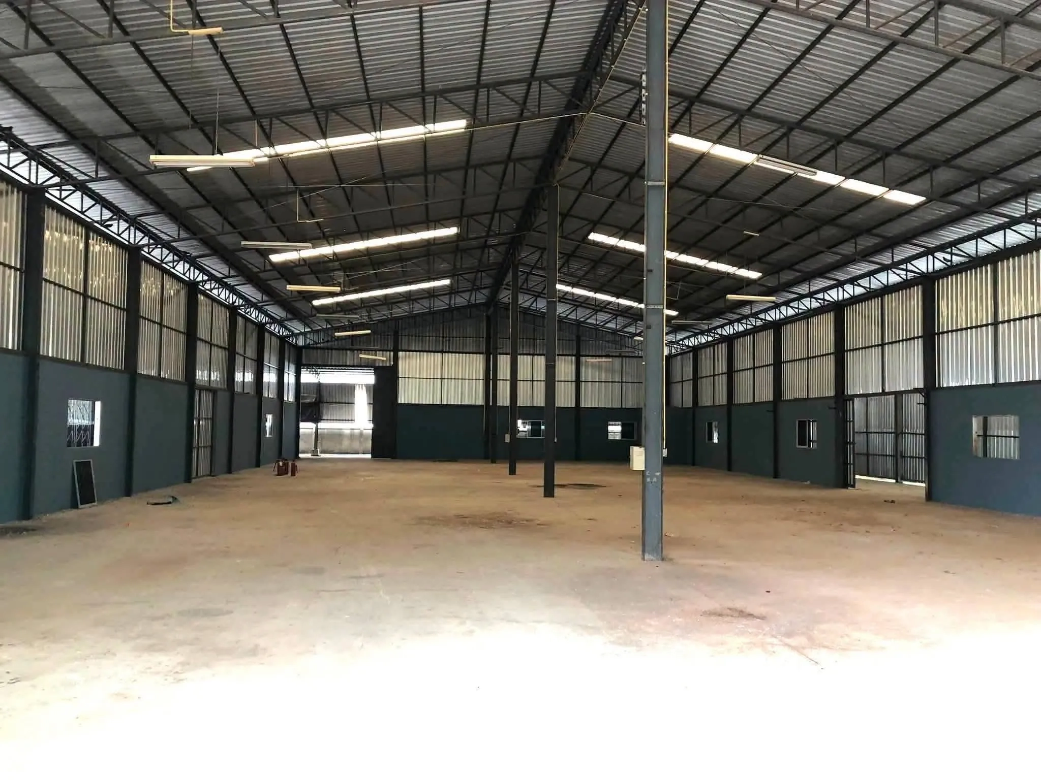 Factory for rent in Plaeng Yao, Chachoengsao - Open warehouse hall with metal cladding, suspended lights, and a concrete floor.