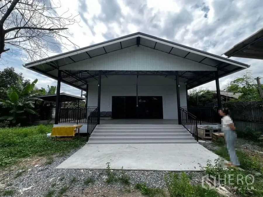 Warehouse for rent in Suan Luang, Bangkok - Facade of gable-roof warehouse with front staircase and sliding glass doors.