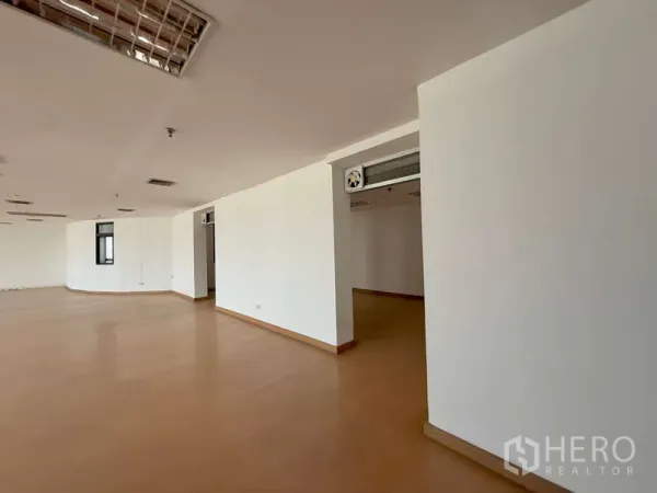 Office Space for rent in Chatuchak, Bangkok - Corner of a large open-plan office with partitioned entry and exposed air-conditioning duct.