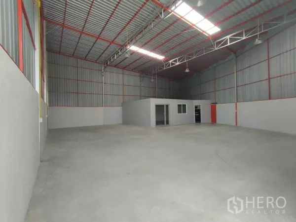 Warehouse for rent in Pak Kret, Nonthaburi - Spacious warehouse interior with skylights, steel trusses, and smooth concrete floor.